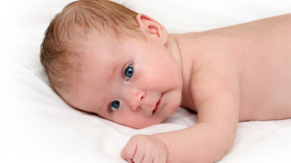 Baby crawling on white sheet