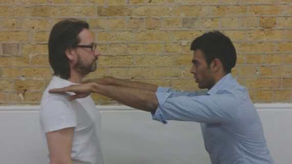 Ameet Bhakta, posture specialist, assessing a client's shoulder alignment during a posture evaluation session
