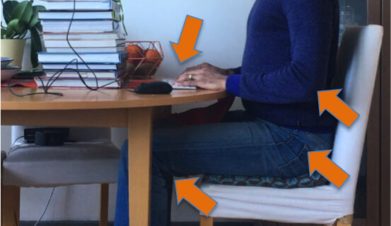 Man sitting at desk working on a laptop with correct posture