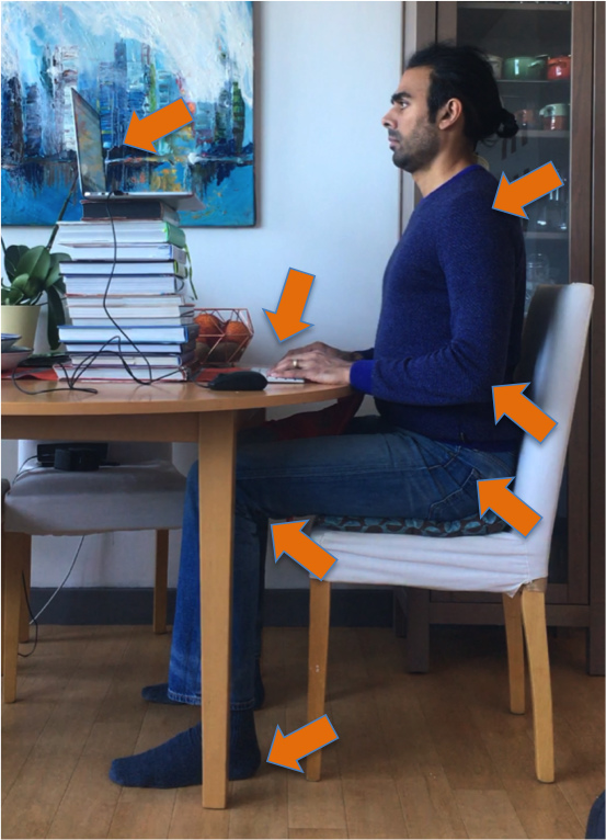 Man sitting at desk working on a laptop with correct posture