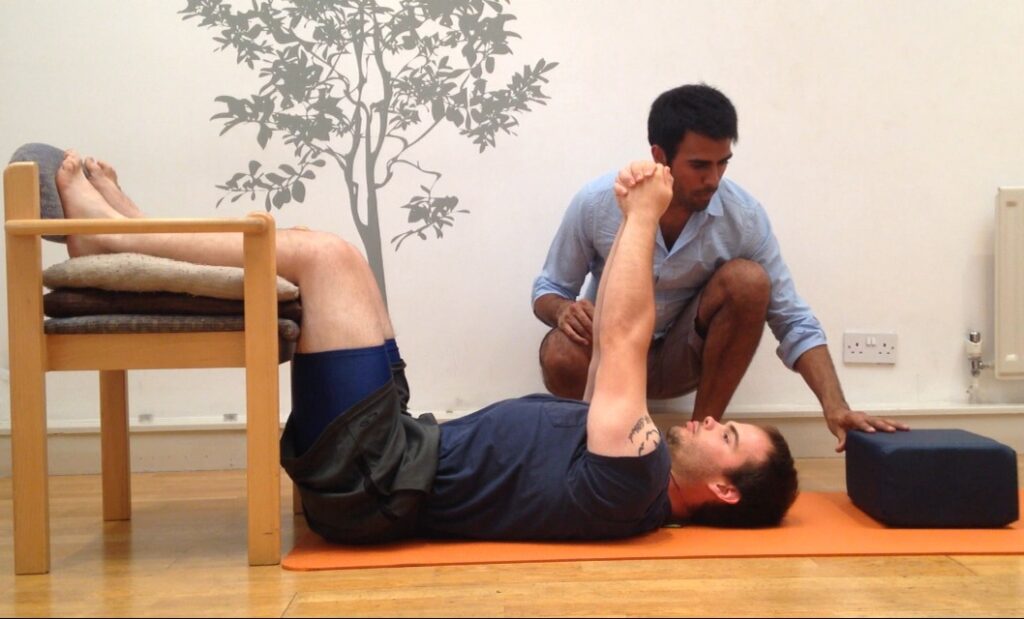 Posture specialist Ameet Bhakta guiding a client through the Egoscue Static Back exercise for posture realignment