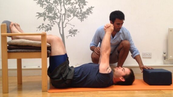 Posture specialist Ameet Bhakta guiding a client through the Egoscue Static Back exercise for posture realignment