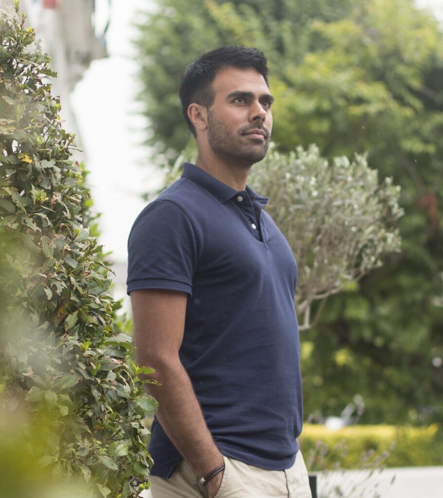 Posture specialist Ameet Bhakta standing with aligned posture outdoors in navy shirt