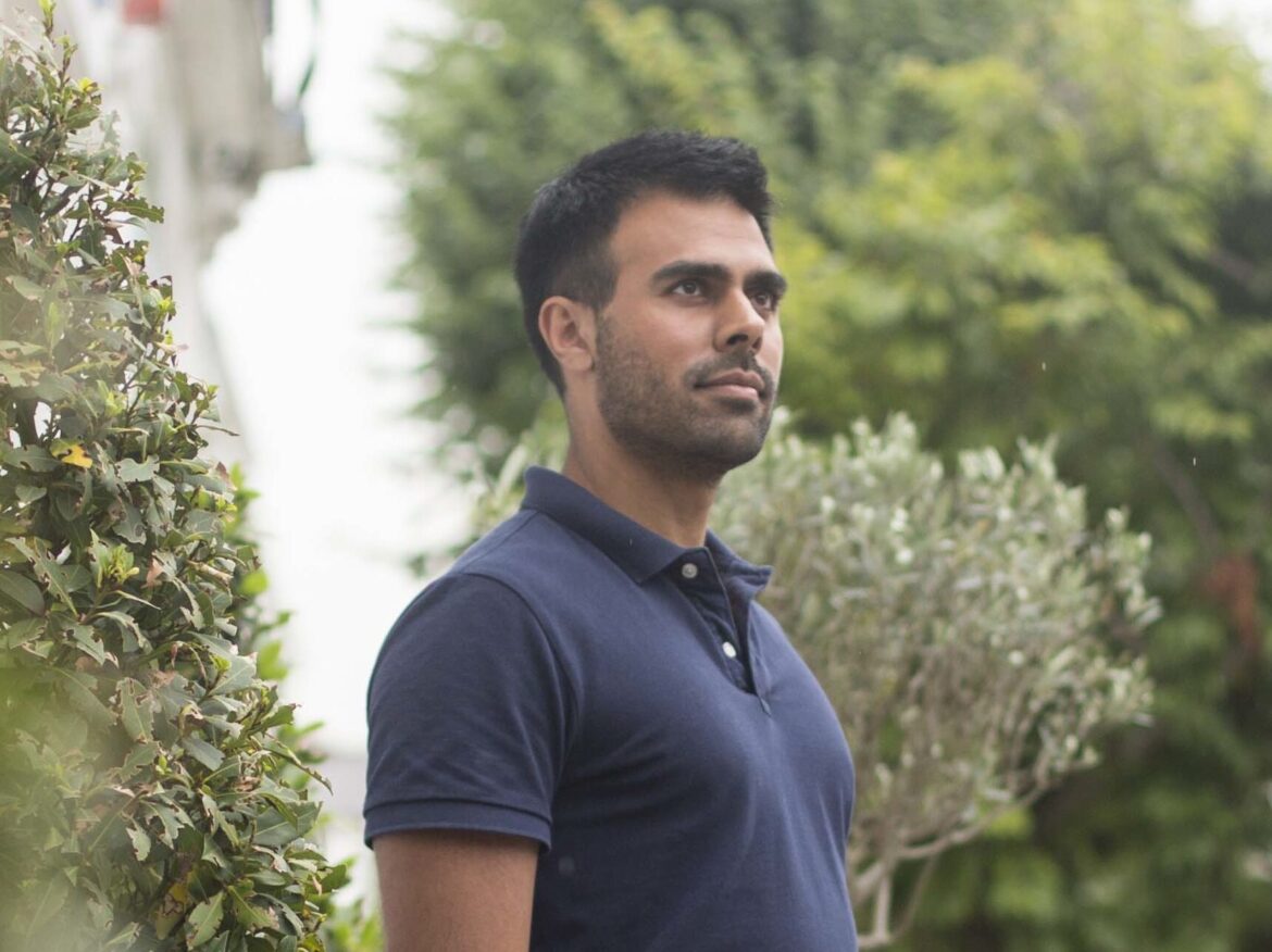Posture specialist Ameet Bhakta standing with aligned posture outdoors in navy shirt
