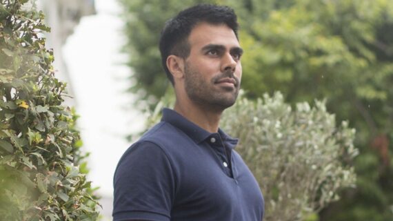 Posture specialist Ameet Bhakta standing with aligned posture outdoors in navy shirt