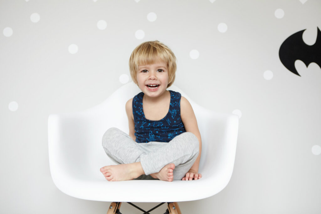 Young child sitting naturally with relaxed posture and smiling