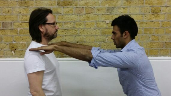 Posture specialist assessing client’s alignment in a full-body posture test — expert care focused on root cause, not symptoms